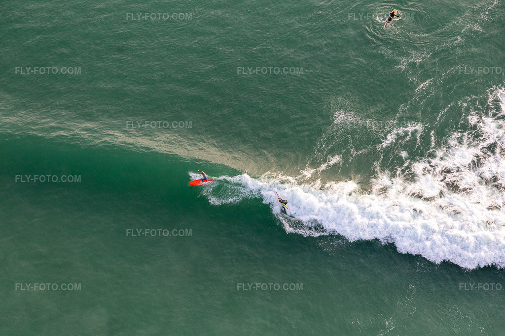Aerial view: Wave surfers in front of the Plage de Tronoën in Saint-Jean-Trolimon in the state Finistere, France. – Photo: IMG_132562.jpg taken on 06/17/2022 by Werner Riehm/FLY-FOTO.com – Resolution of the original: 5472 x 3648 px