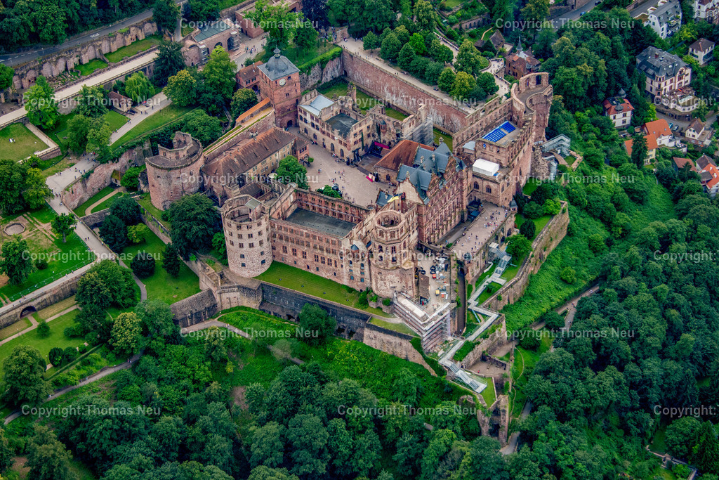 heidelberger-schloss-luftaufnahme-heidelberg-neckar-altstadt-fotografie-thomas-neu_02 | Das Heidelberger Schloss aus der Vogelperspektive: Die historische Schlossruine thront oberhalb der Heidelberger Altstadt und zählt zu den bekanntesten Sehenswürdigkeiten Deutschlands. Die Luftaufnahme zeigt das Schlossensemble mit seinen mächtigen Mauern, Türmen und Innenhöfen sowie den Neckar, die Alte Brücke und die dicht bebaute Altstadt Heidelbergs. Die Kombination aus Renaissancearchitektur, bewaldeten Hängen des Königstuhls und dem Flusslauf des Neckars verleiht dieser Aufnahme eine besondere Atmosphäre. Ideal als Wandbild für Liebhaber historischer Städte, Architektur und beeindruckender Luftbilder aus Baden-Württemberg