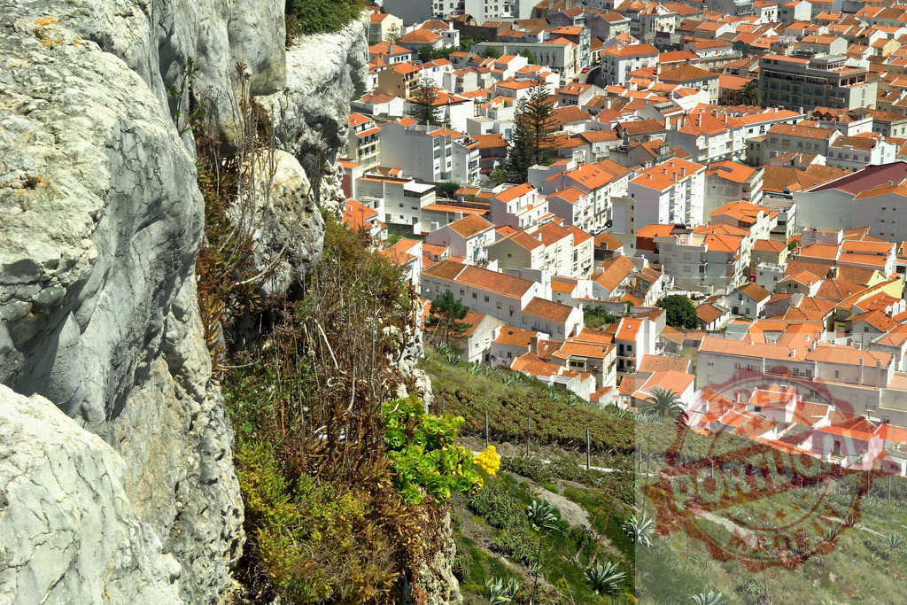 Nazaré cityscape view from cliff overlooking red roofs | Cliffside overlooking the town of Nazaré, Portugal with white buildings and orange roofs - Realisiert mit Pictrs.com