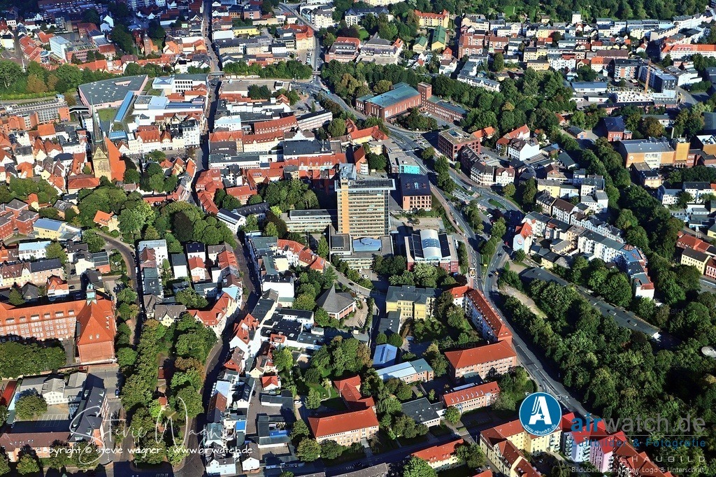 Luftbild Flensburg, Rathausplatz, Deutsches Haus, St.Nikolei-Kirche | Das Flensburger Rathaus befindet sich am Rathausplatz 1, einem zentralen Punkt in der Nähe der Flensburger Innenstadt, direkt am Rande des Neumarkts und in unmittelbarer Nähe zur St.-Nikolai-Kirche am Südermarkt. Der Rathausplatz, der ursprünglich als unbebaute Fläche entstand, grenzt an die Rote Straße, wo einst das Rote Tor die Stadtgrenze markierte. - Das Deutsches Haus, ein historisches Gebäude, liegt in unmittelbarer Nähe zum Rathaus und zum Neumarkt, wobei es Teil der städtebaulichen Umgestaltung der 1960er Jahre war, die auch den Abriss alter Bauten in der Umgebung einschloss. - Die St.-Nikolai-Kirche, eine der Hauptkirchen von Flensburg, befindet sich am Südermarkt und bildet städtebaulich das Zentrum des jüngsten der vier historischen Siedlungskerne der Stadt.