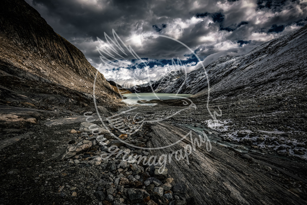 high alpine silence - switzerland | Diese Aufnahme zeigt ein typisches hochalpines Gletschertal der Zentralschweiz: karge Felsflanken, frisches Moränenmaterial, ein milchig-türkisfarbener Gletschersee und ein offenes Wolkenbild. Die kühlen Farbtöne und die klare Struktur des Gesteins vermitteln eindrücklich die Härte und Schönheit dieser Bergwelt.