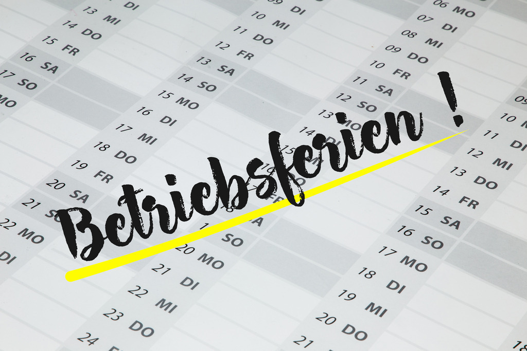 BETRIEBSFERIEN Kalender (Symbolbild) | Auf einem Kalender steht in großer Schrift das Wort BETRIEBSFERIEN (Symbolbild) - Realisiert mit Pictrs.com