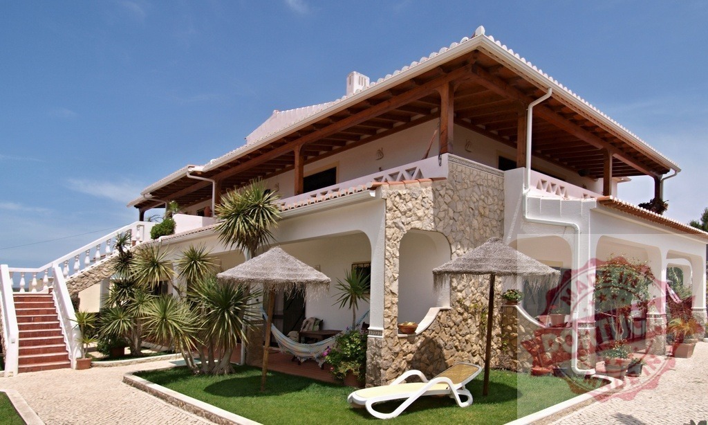 Luxury villa with stone facade and balconies | Charming vacation home featuring multiple terraces, sun loungers, and tropical plants - Realisiert mit Pictrs.com