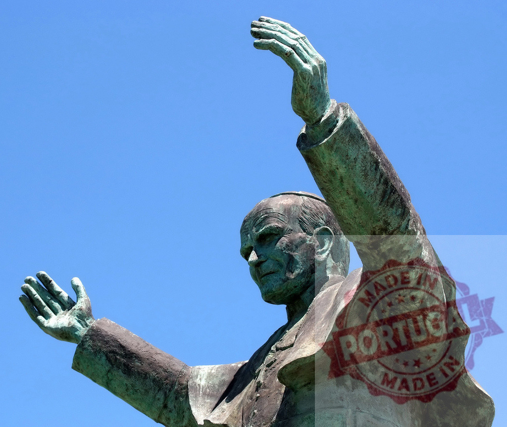 Pope John Paul II bronze statue blessing religious monument | Pope John Paul II statue showing blessing gesture against clear blue sky - Realized with Pictrs.com