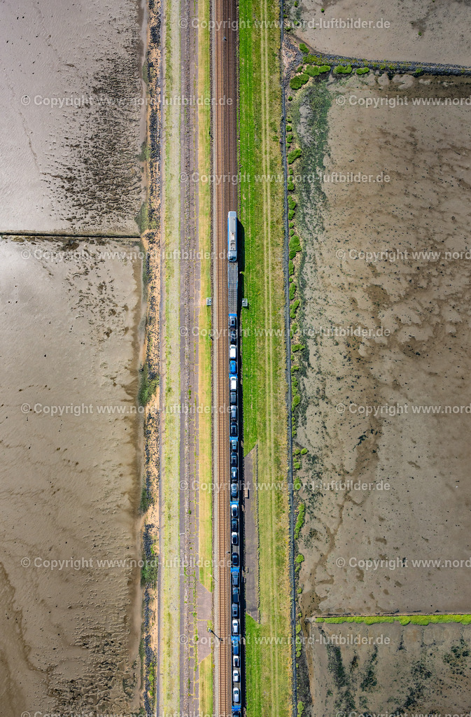 Sylt_Hindenburgdamm_Autozug_Senkrechtaufnahme_Blauer_Zug_ELS_0366130825 | SYLT 21.06.2025 Wattenmeer der Nordsee- Küste am Hindenburgdamm in Sylt im Bundesland Schleswig-Holstein. // Wadden Sea of North Sea Coast on Hindenburgdamm in Sylt in the state Schleswig-Holstein. Foto: Martin Elsen