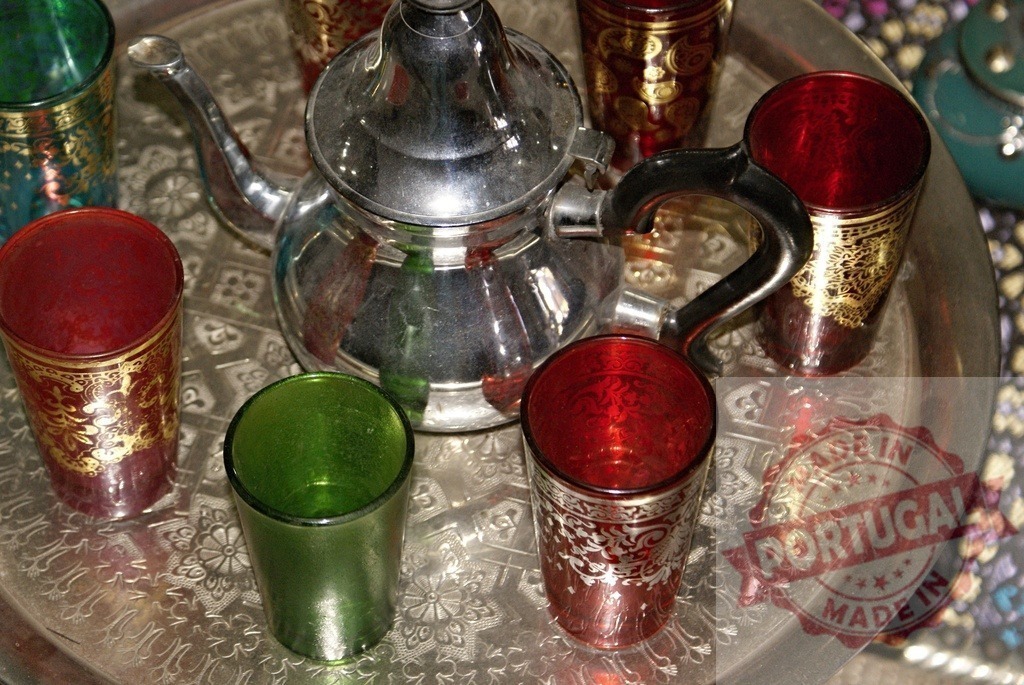 Moroccan mint tea ritual with traditional teapot and colorful glasses | Traditional Moroccan teapot and ornate glasses arranged on a metal tray, representing hospitality - Realized with Pictrs.com