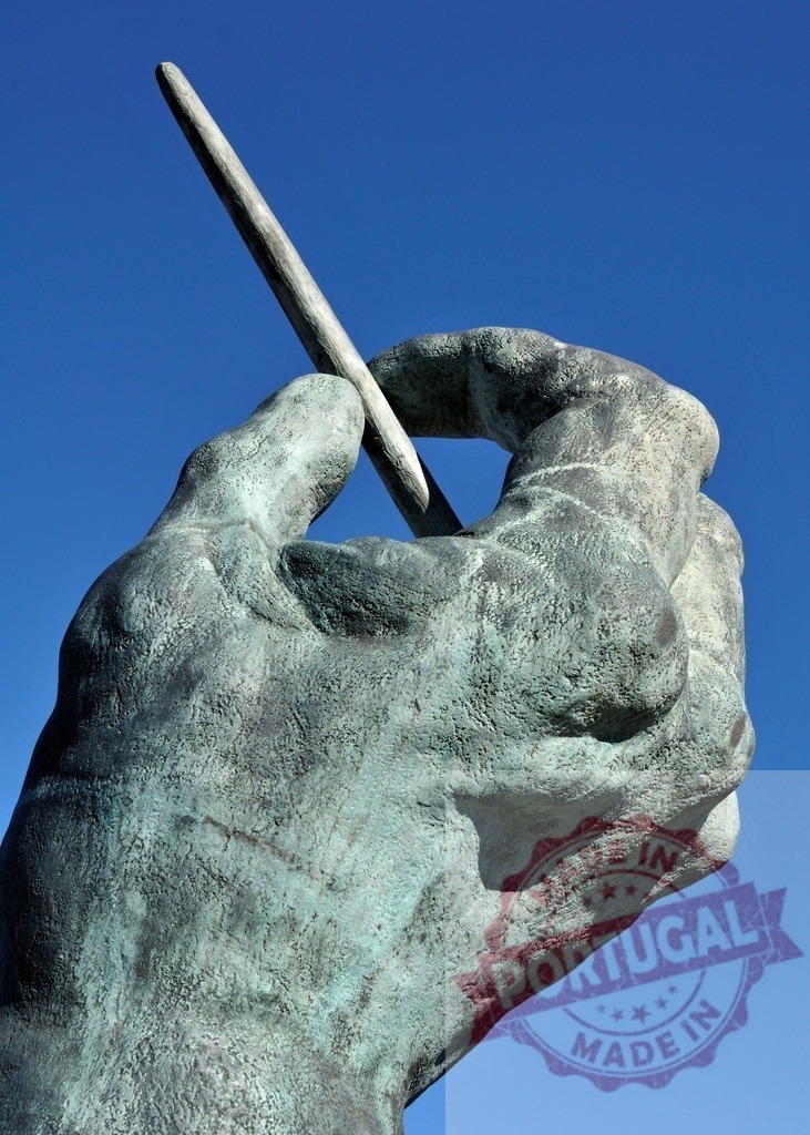 Bronze hand sculpture holding pen against blue sky | Bronze hand sculpture holding a pen on a clear blue sky background - Realized with Pictrs.com