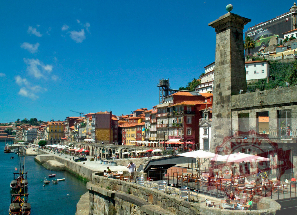 Porto Ribeira district and Douro River waterfront | Historic Ribeira district buildings lining the Douro River in Porto, Portugal with people relaxing at outdoor cafes - Realisiert mit Pictrs.com