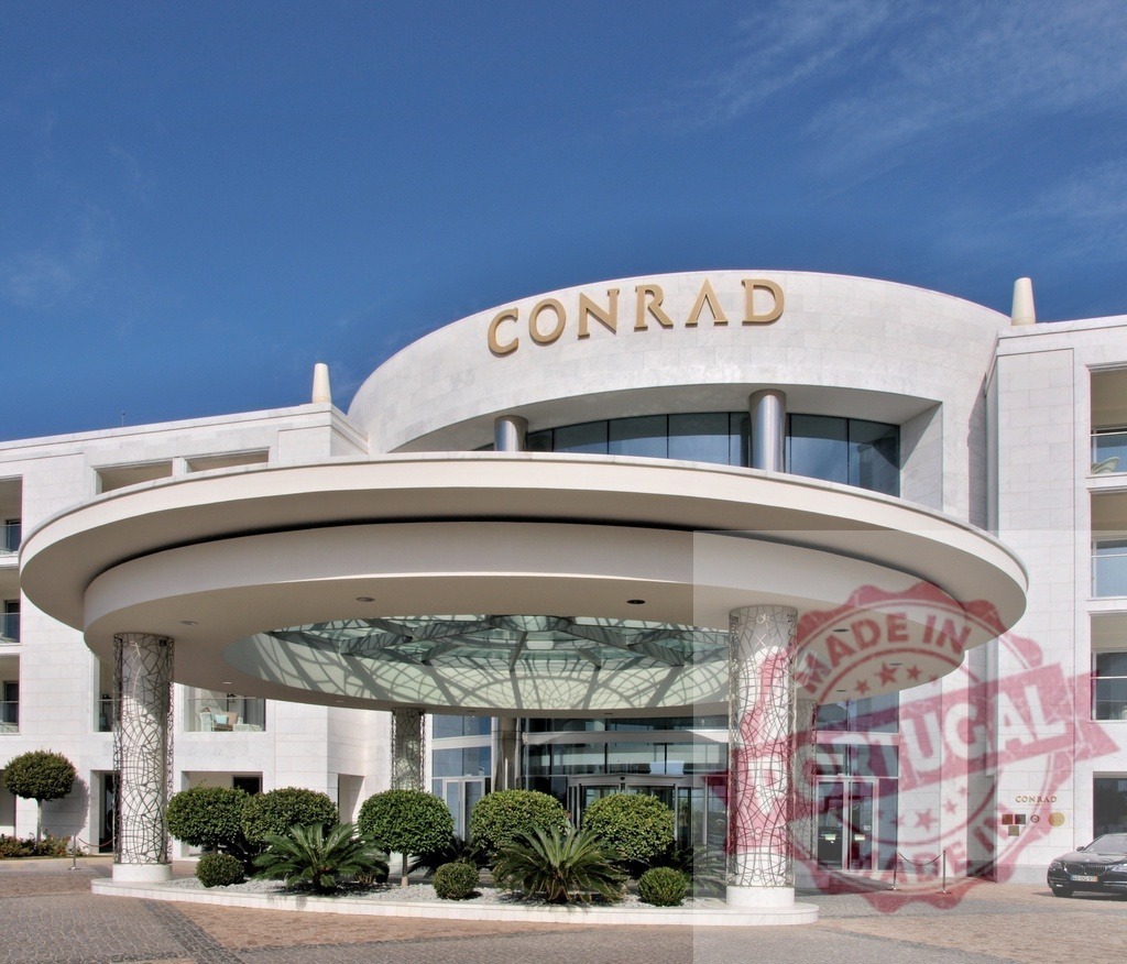 Conrad Algarve hotel luxury resort entrance in Portugal | Conrad Algarve hotel architecture and modern entrance with lush green plants under a clear blue sky - Realized with Pictrs.com
