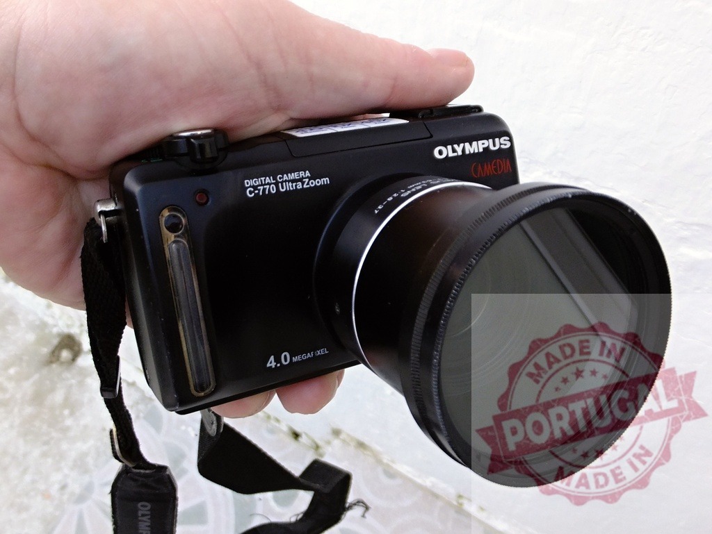 Holding an Olympus Camedia digital camera | Hand holding a black Olympus Camedia C-770 Ultra Zoom digital camera - Realized with Pictrs.com