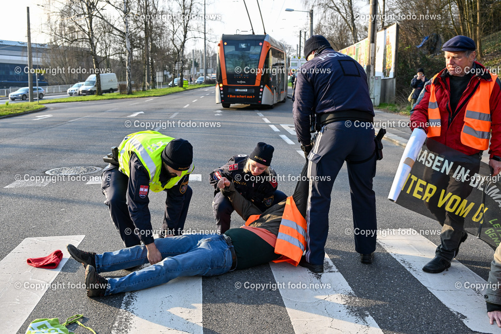  Klimagegner Linz Waldeggstrasse_ Klimakleber_ 20.03.2023-40 | 20.03.2023, Linz, AUT, Klimagegner Linz Klimakleber, im Bild Klimagegner kleben auf der Strasse, Linz Waldeggstrasse, Polizei, Verkehr, Zebrastreifen, Fussgaengeruebergang, Transparent, Demo, Klimawandel