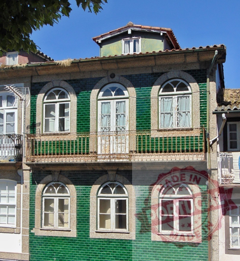Guimarães house with green ceramic tiles and balcony. Region Norte - Portugal | Traditional house facade featuring green ceramic tiles and arched windows in Guimarães, Portugal - Realisiert mit Pictrs.com