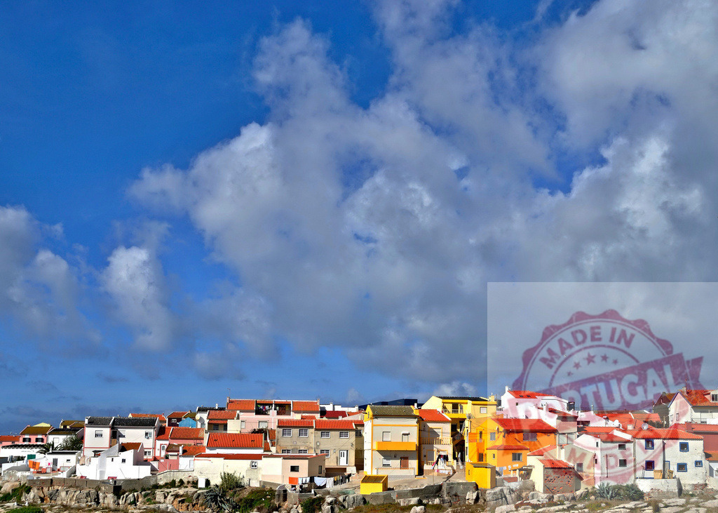 Baleal coastal village with colorful houses and red roofs. Centro - Portugal | Baleal village houses with bright facades and red roofs under a blue sky with clouds - Realisiert mit Pictrs.com