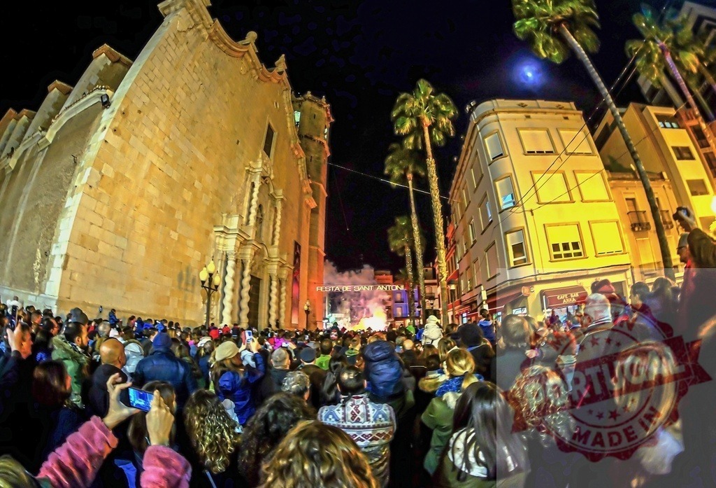 Crowd celebrating Festa de Sant Antoni in Vilanova i la Geltrú | People gathered at night in the street watching a bonfire during the Sant Antoni festival - Realized with Pictrs.com