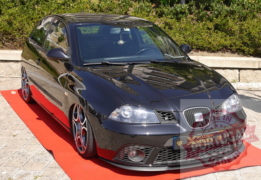 Modified SEAT Ibiza hatchback on red carpet at car show | Custom black car with low suspension and unique wheels on display - Realisiert mit Pictrs.com