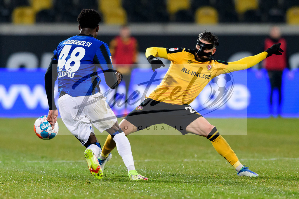 SGDHSV20220114_038 | Fussball, Herren: Faride Alidou (Hamburger SV) und Brandon Borrello (SG Dynamo Dresden) im Zweikampf bei dem Spiel der 2. Bundesliga zwischen SG Dynamo Dresden und Hamburger SV im Rudolf-Harbig-Stadion am 14.01.2022 in Dresden, Deutschland.DFB / DFL REGULATIONS PROHIBIT ANY USE OF PHOTOGRAPHS AS IMAGE SEQUENCES AND/OR QUASI-VIDEO. - Realisiert mit Pictrs.com