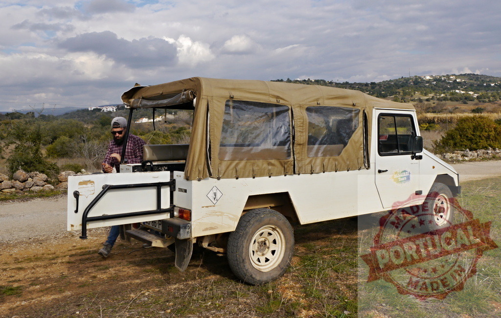 Man preparing for an off-road safari tour adventure | Man with beard sitting on the tailgate of an off-road vehicle during a safari tour - Realized with Pictrs.com