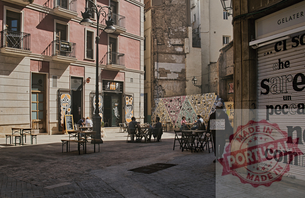 Barcelona Gothic Quarter street cafe scene with street art | People relaxing at an outdoor cafe in Barcelona's Gothic Quarter with vibrant street art - Realized with Pictrs.com
