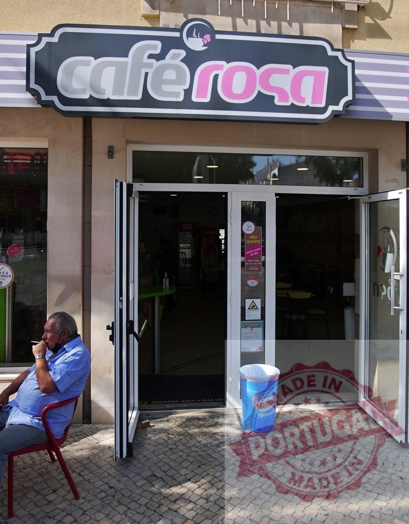 Man smoking outside Café Rosa cafe in Lisbon | Man sitting on a red chair, smoking a cigarette outside a cafe on a sunny day - Realisiert mit Pictrs.com