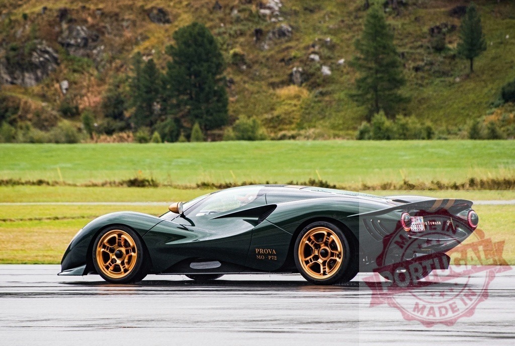 De Tomaso P72 supercar driving on wet road | De Tomaso P72 supercar with gold wheels on a wet track with grass and mountains - Realized with Pictrs.com