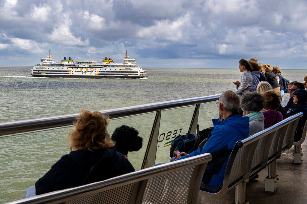 Kurs auf Auszeit: Der magische Moment der Anreise nach Texel | Passagiere an Deck genießen den Panoramablick auf die offene Nordsee, während die entgegenkommende TESO-Fähre „Dokter Wagemaker“ auf dem Wasser vorbeizieht. Die spürbare Vorfreude auf den Inselurlaub, die frische Meeresbrise und der weite Horizont fangen das klassische Urlaubsgefühl vor Texel perfekt ein. Ein stimmungsvolles Motiverlebnis rund um Schifffahrt, Reisefieber und gelungene Auszeiten, das sich ideal für redaktionelle Beiträge, Tourismusmedien sowie Reiseberichte eignet. - Realisiert mit Pictrs.com
