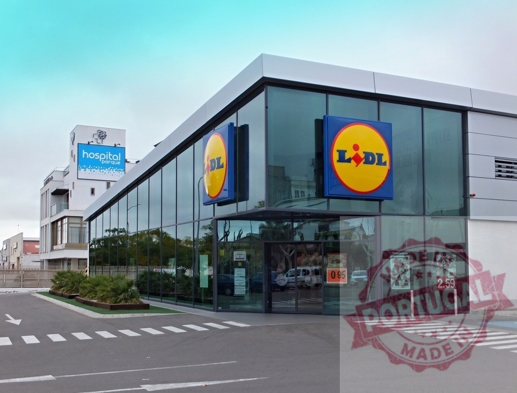 Lidl supermarket exterior building and Hospital Parque sign | Lidl supermarket building with glass facade and Hospital Parque billboard in the background - Realized with Pictrs.com