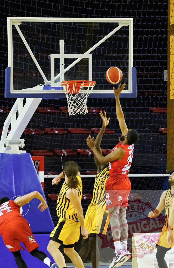 Basketball players competing on court shooting hoop | Athlete in red uniform jumping up making a shot during an intense basketball game - Realized with Pictrs.com