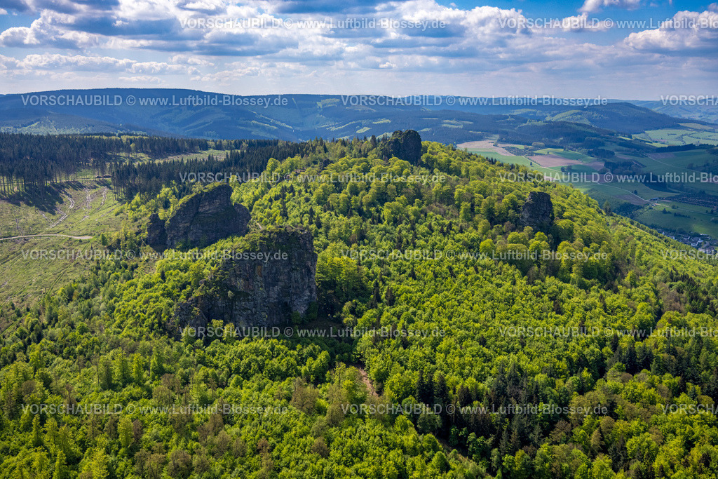 Olsberg240503770 | Luftbild, Bruchhauser Steine, Sehenswürdigkeit in waldiger Hügellandschaft, vier Felsen mit Namen Ravenstein, Goldstein, Bornstein und Feldstein mit Gipfelkreuz, Fernsicht mit blauem Himmel und Wolken, Bruchhausen, Olsberg, Sauerland, Nordrhein-Westfalen, Deutschland