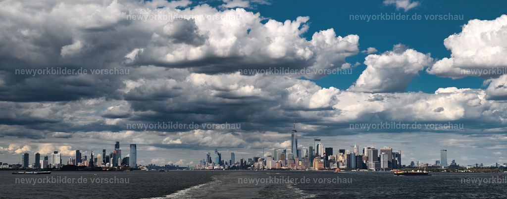 Vom Heck der Staten Island Ferry öffnet sich ein Panorama: Manhattan erhebt sich stolz, eingerahmt vom Hudson River – ein Bild voller Freiheit und Energie | Vom Heck der Staten Island Ferry entfaltet sich ein Bild, das die Seele von New York einfängt. Vor dir erhebt sich die Skyline von Manhattan, stolz und kraftvoll, eingerahmt vom glitzernden Hudson River. Links liegt Jersey City, rechts Brooklyn – zwei Welten, die gemeinsam das Panorama dieser Metropole formen. Die Weite des Wassers vermittelt ein Gefühl von Freiheit, während die Türme von Manhattan wie Symbole für Energie und unbegrenzte Möglichkeiten in den Himmel ragen. Dieses Motiv erzählt von Bewegung, von der Verbindung zwischen Stadt und Wasser und von Augenblicken, die man nie vergisst. Es ist ein Bild, das die Essenz New Yorks transportiert: Dynamik, Vielfalt und die unvergleichliche Atmosphäre einer Stadt, die niemals stillsteht. Ein Moment, der die Magie des Big Apple in seiner reinsten Form zeigt.