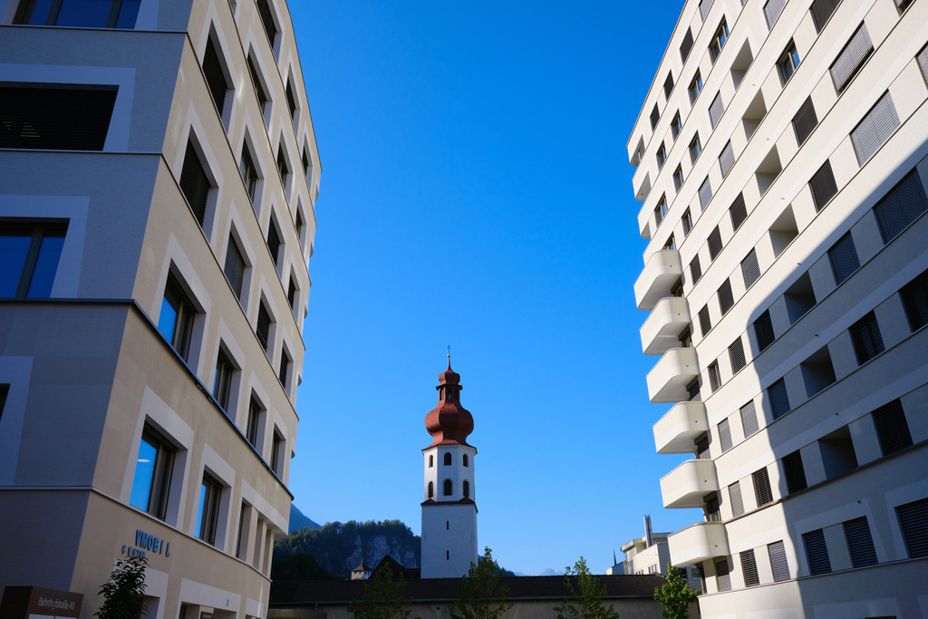 Blick auf die Johanniterkirche durch zwei Wohnhäuser | Feldkirch, Austria - October 11, 2023: Blick auf die Johanniterkirche durch zwei Wohnhäuser. - Realisiert mit Pictrs.com