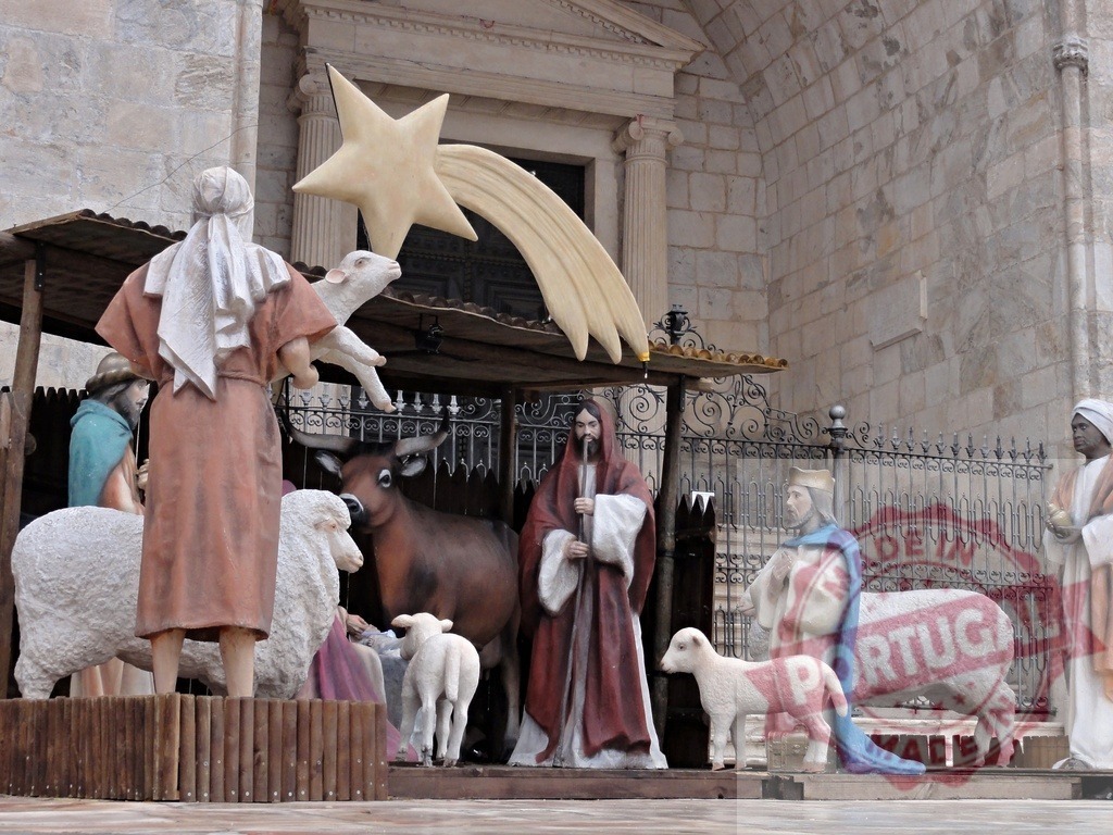 Nativity scene representing the birth of Jesus with shepherds and magi bringing gifts | Outdoor nativity scene with colorful statues of the holy family, shepherds, magi, sheep, ox and donkey, under a comet star - Realisiert mit Pictrs.com