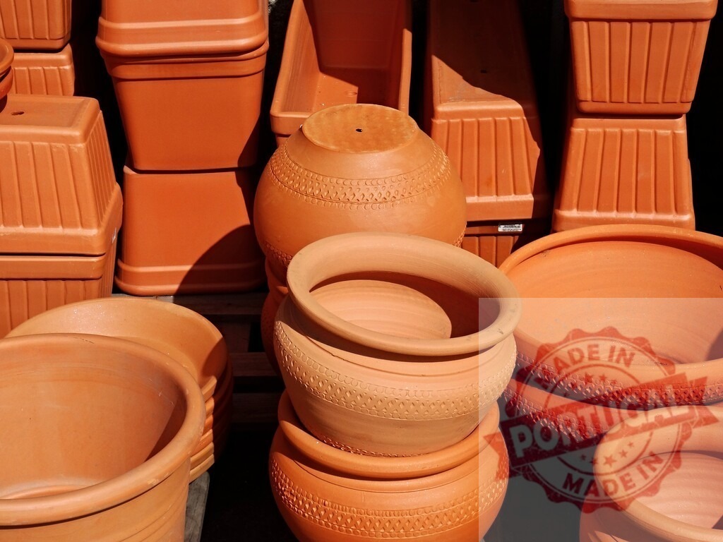 Terracotta pots and planters for gardening | Terracotta pots of various shapes and sizes stacked, ready for gardening and planting - Realisiert mit Pictrs.com