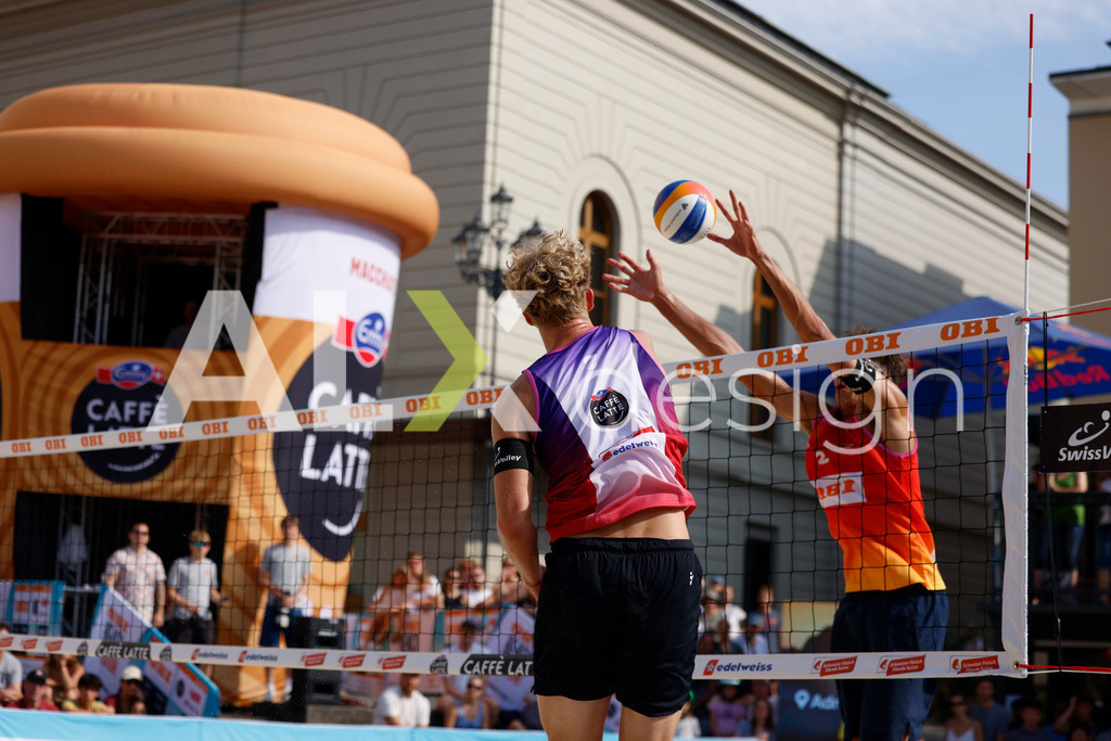 Obi BeachTour 2026 - Basel | BASEL, SWITZERLAND - JULY 19: MATHIS KÄLIN (SUI) attack / spike against LUC EMANUEL FLÜCKIGER (SUI) block during the Obi BeachTour 2026 match between DILLIER / FLÜCKIGER (SUI) and BREER / KÄLIN (SUI) at Barfüsserplatz on July 19, 2026 in Basel, Switzerland. - Realisiert mit Pictrs.com