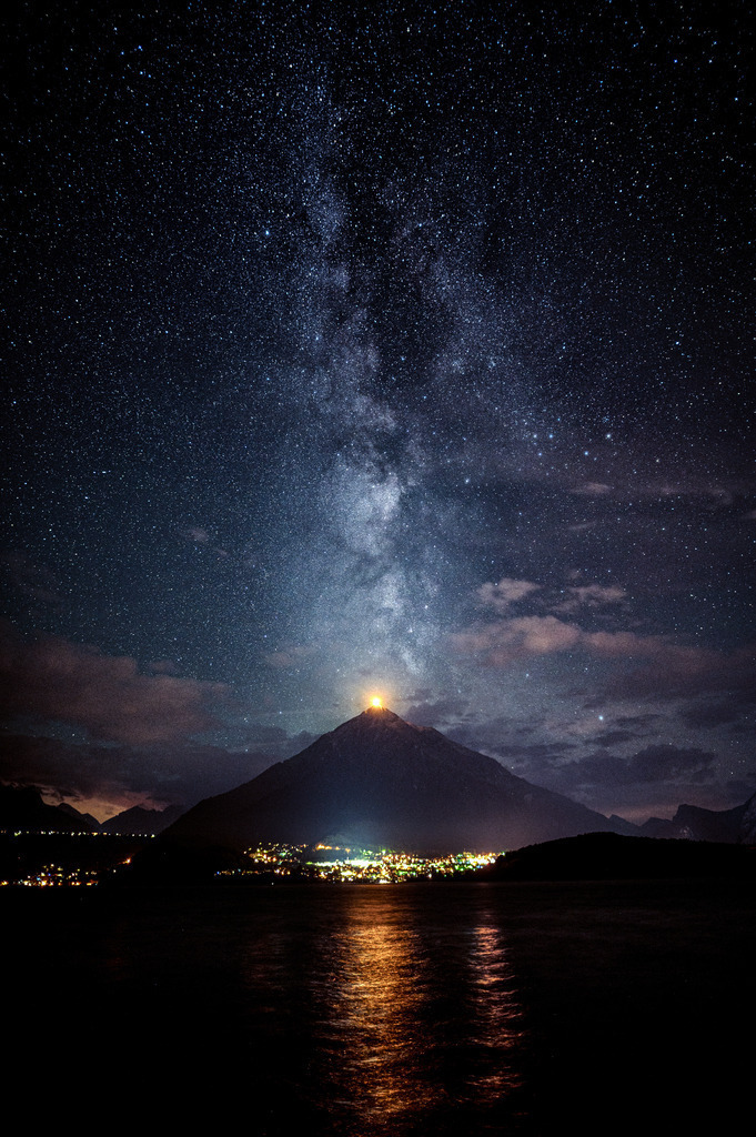 Niesen Licht | Zuerst hatte ich zu Hause um 1 Uhr morgens ein paar Aufnahmen der Milchstrasse gemacht aber bemerkt, dass ich weiter Richtung Interlaken das Zentrum über dem Niesen haben könnte. So habe ich mich auf das Fahrrad geschwungen und zwischen Gunten und Merligen hatte ich das Bild, das mir vorschwebte - gegen 2 Uhr morgens. 
Befremdlich, wie hell Spiez um diese Zeit noch erleuchtet ist.
-----------------------------------------------------------------
First I took some pictures of the Milky Way at home at 1am but noticed that further towards Interlaken I could have the center above the Niesen. So I got on my bike and between Gunten and Merligen I had the picture I had in mind - around 2 o'clock in the morning.
Disconcerting how brightly Spiez is still illuminated at this time.
-----------------------------------------------------------------
Dieser Druck ist in einer limitierten Auflage von 5 Exemplaren erhältlich. 
This print is available in a limited edition of 5 copies. 
http://art.hess.photography/148-niesen-licht.html - Realisiert mit Pictrs.com