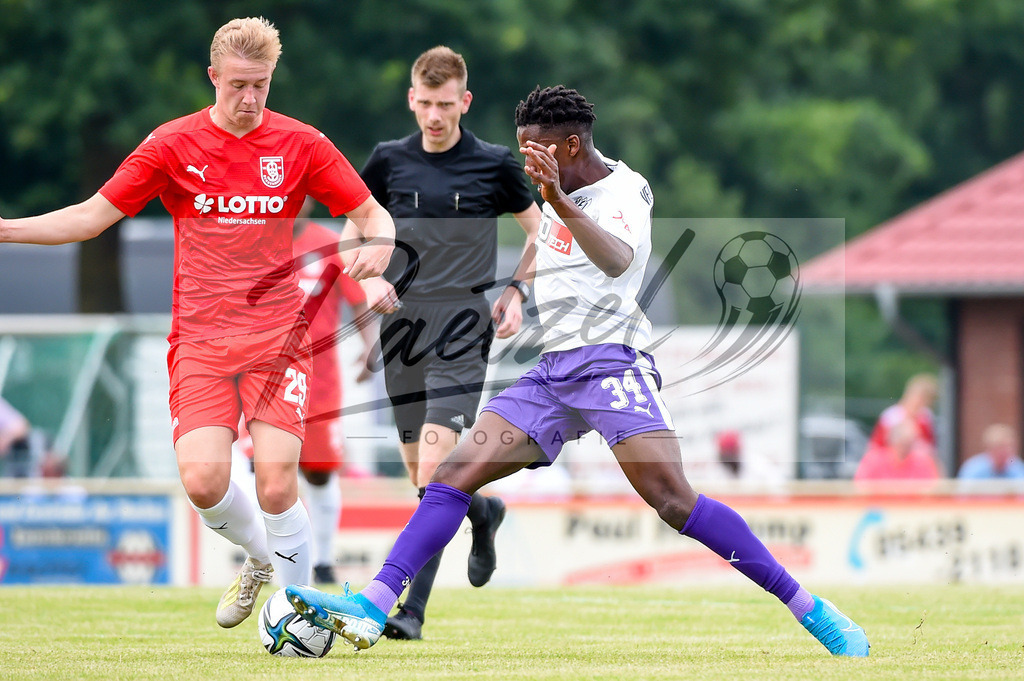 BSBOSN_20210626_0101 | Fussball, Herren: Jonas Finke (TuS Bersenbrueck) und Hakim Traore (VfL Osnabrueck) im Zweikampf beim Testspiel zwischen TuS Bersenbrueck und VfL Osnabrueck im Hasestadion am 26.06.2021 in Bersenbrueck, Deutschland. - Realisiert mit Pictrs.com