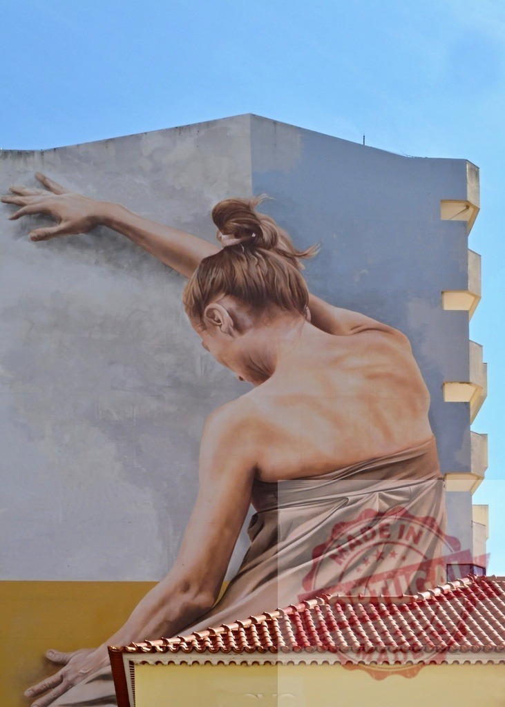 Woman mural reaching wall on building exterior | Large street art painting of a woman reaching and interacting with a building wall - Realisiert mit Pictrs.com