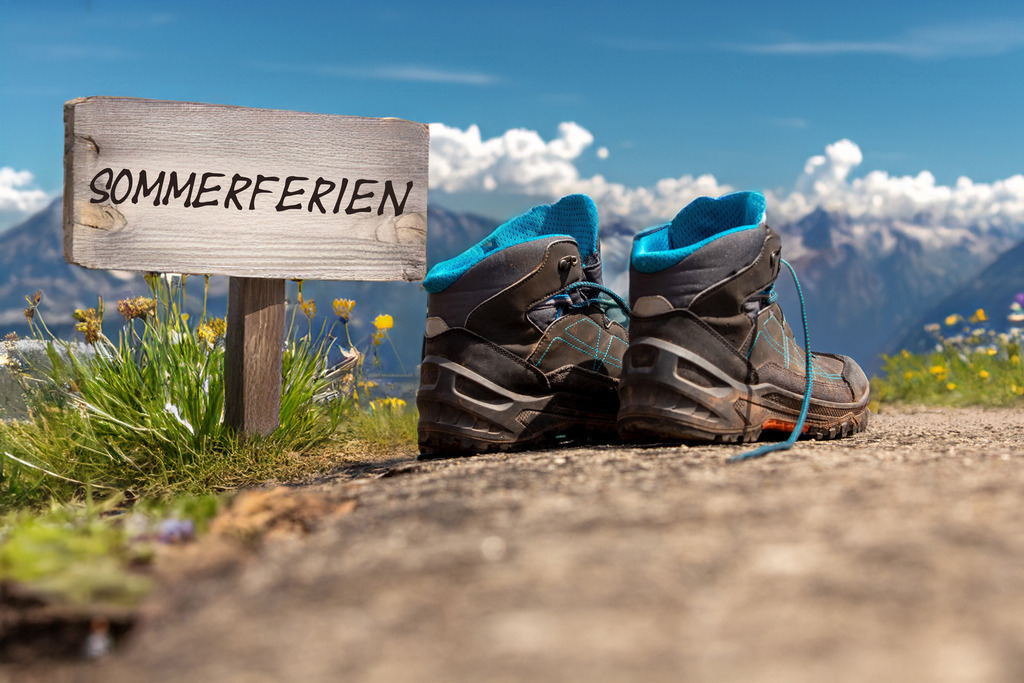 Symbolbild Betriebsferien/Sommerferien: Wanderschuhe vor alpiner Kulisse und Schild mit der Aufschrift SOMMERFERIEN | Symbolbild Betriebsferien/Sommerferien: Wanderschuhe vor alpiner Kulisse und Schild mit der Aufschrift SOMMERFERIEN - Realisiert mit Pictrs.com