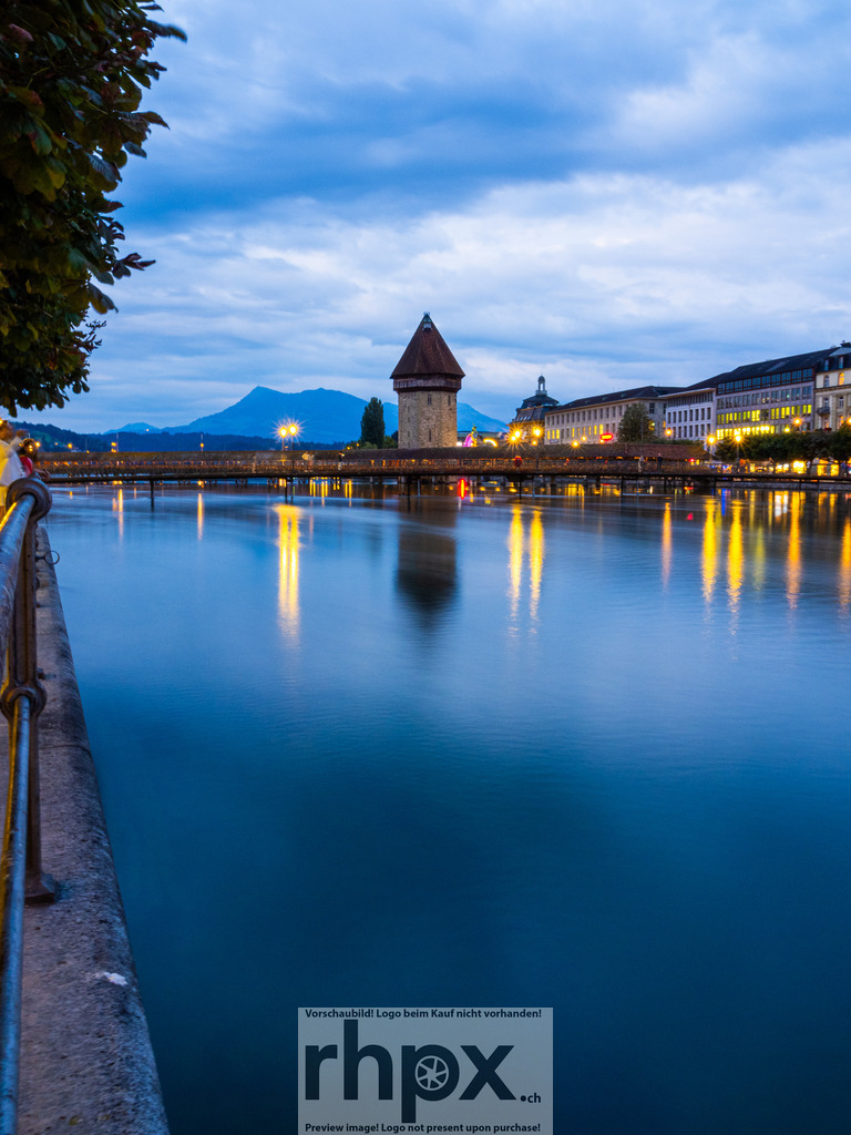 Kapellbrücke Luzern | Architektur. Stille. Eleganz.Die Kapellbrücke und der markante Wasserturm spiegeln sich sanft im ruhigen Wasser der Reuss, während der Pilatus im Hintergrund über der Stadt wacht. Ein stimmungsvoller Moment in der blauen Stunde, der die zeitlose Schönheit Luzerns einfängt.Wähle unter "Produktauswahl" dein Wunschformat: Vom klassischen Wandbild über Puzzle &amp; Tassen bis zum digitalen Download (z.B. als Handy-Hintergrund). - Realisiert mit Pictrs.com