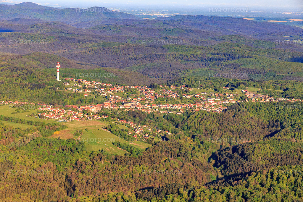 Aerial view: View of the town next to the Tour hertzienne de Goetzenbruck radio tower in the Northern Vosges Mountains from the west in Goetzenbruck in the state Moselle, France.Photo: IMG_145774.jpg taken on 04/30/2025 by Werner Riehm/FLY-FOTO.comResolution of the original: 5472 x 3648 px