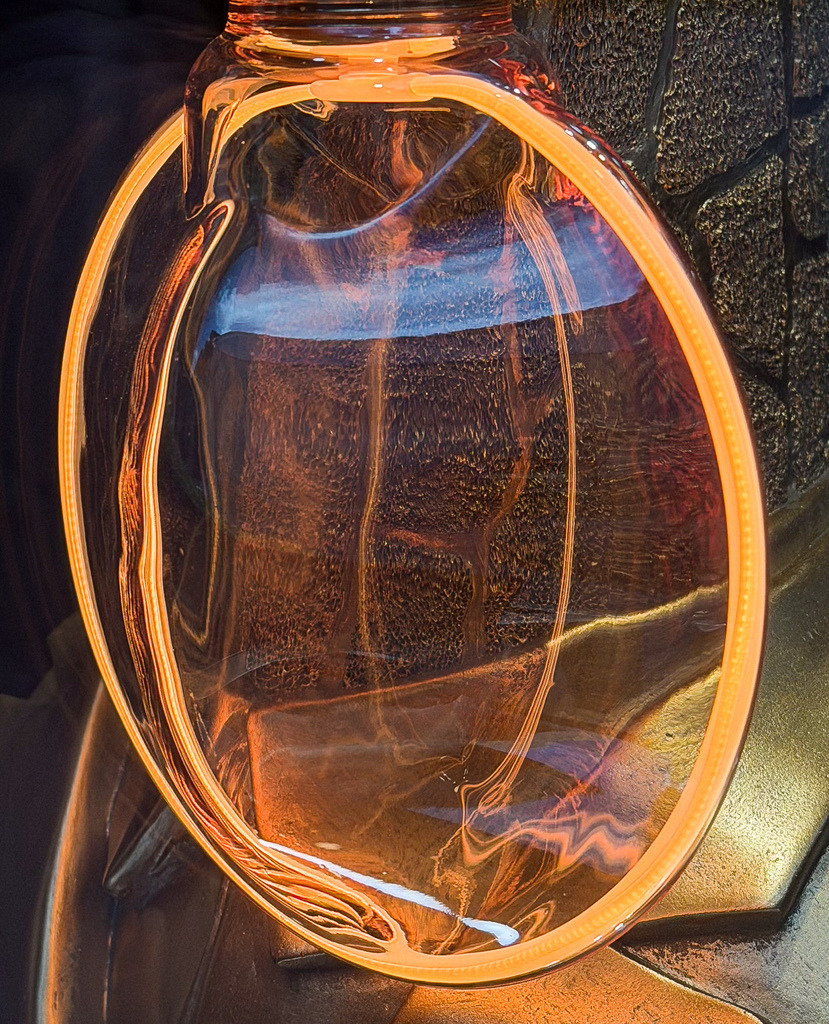 Glühender Orbit – Abstraktes Lichtkunst Wandbild Lörrach | Ein faszinierendes Spiel aus Licht, Glas und purer Energie. Diese hochexklusive, detailreiche Makroaufnahme fängt die spektakulären Lichtbrechungen einer Design-Glaskugellampe in einem Schaufenster in Lörrach ein. Das intensiv leuchtende Orange und die organischen Strukturen im Inneren des Glases verschwimmen im harten Kontrast zur Dunkelheit zu einem hypnotischen, fast surrealen Kunstwerk. Ein absolut moderner, kraftvoller Design-Blickfang für minimalistische Wohnräume, urbane Lofts oder stilvolle Lounges. Empfohlen als Großformat unter Acrylglas für maximale Leuchtkraft. - Realisiert mit Pictrs.com