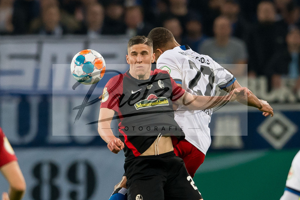 HSVSCF20220419_117 | Fussball, Herren: Roland Sallai (SC Freiburg) und Josha Vagnoman (Hamburger SV) im Zweikampf beim DFB-Pokal-Halbfinalspiel zwischen Hamburger SV und SC Freiburg im Volksparkstadion am 19.04.2022 in Hamburg, Deutschland.DFB / DFL REGULATIONS PROHIBIT ANY USE OF PHOTOGRAPHS AS IMAGE SEQUENCES AND/OR QUASI-VIDEO. - Realisiert mit Pictrs.com