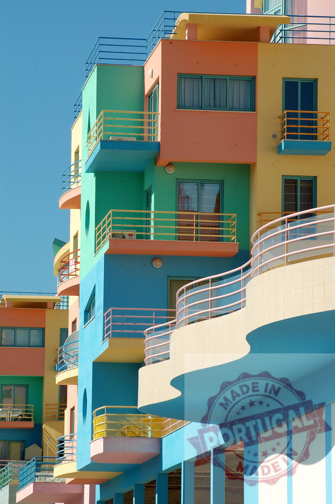 Colorful pastel modern building facade with geometric balconies | Vivid pastel-colored building facade featuring multiple balconies and clean geometry under a blue sky - Realized with Pictrs.com