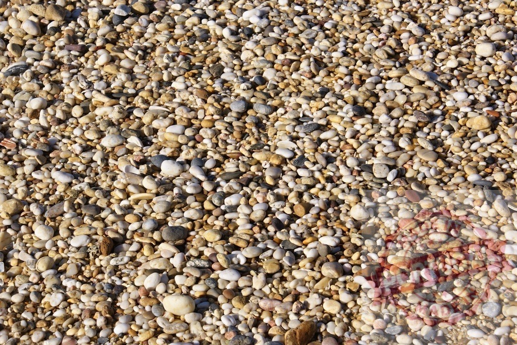 Pebbles creating textured beach background pattern | Pebbles forming a natural textured background on a beach or riverbed - Realized with Pictrs.com