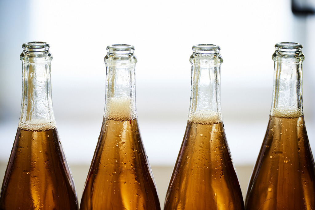 Sektkellerei Szigeti | Gols, Austria - February 19, 2018: Sektkellerei Szigeti; Sektflaschen ohne Verkorkung auf dem Fliessband. - Realisiert mit Pictrs.com