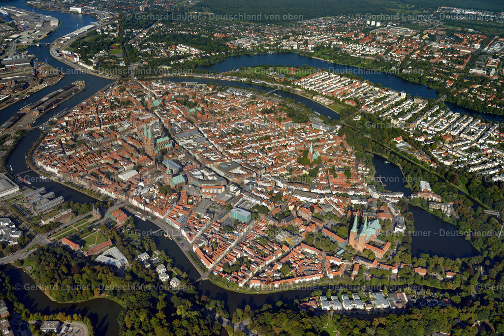 3293110 | Altstadtinsel Lübeck ist eine norddeutsche Stadt, die sich durch ihre Bauten im Stil der Backsteingotik auszeichnet. Diese entstanden im Mittelalter, als Lübeck die Hauptstadt der Hanse war. Das Wahrzeichen der Stadt ist das Holstentor aus Backstein, das im Jahr 1478 vollendet wurde und dazu diente, die auf einer Insel in der Trave gelegene Altstadt abzuschirmen. Die Marienkirche, die nach dem 2. Weltkrieg wiederaufgebaut wurde, ist ein im 13.–14. Jahrhundert errichteter Backsteinbau, der als architektonisches Vorbild für viele nordeuropäische Kirchen diente