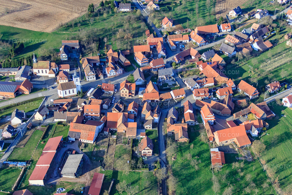 Aerial view: Village with Catholic Church of Saint George and Protestant Church of the South in Keffenach in the state Bas-Rhin, France. – Photo: IMG_38760.jpg taken on 03/20/2011 by Werner Riehm/FLY-FOTO.com – Resolution of the original: 4395 x 2930 px