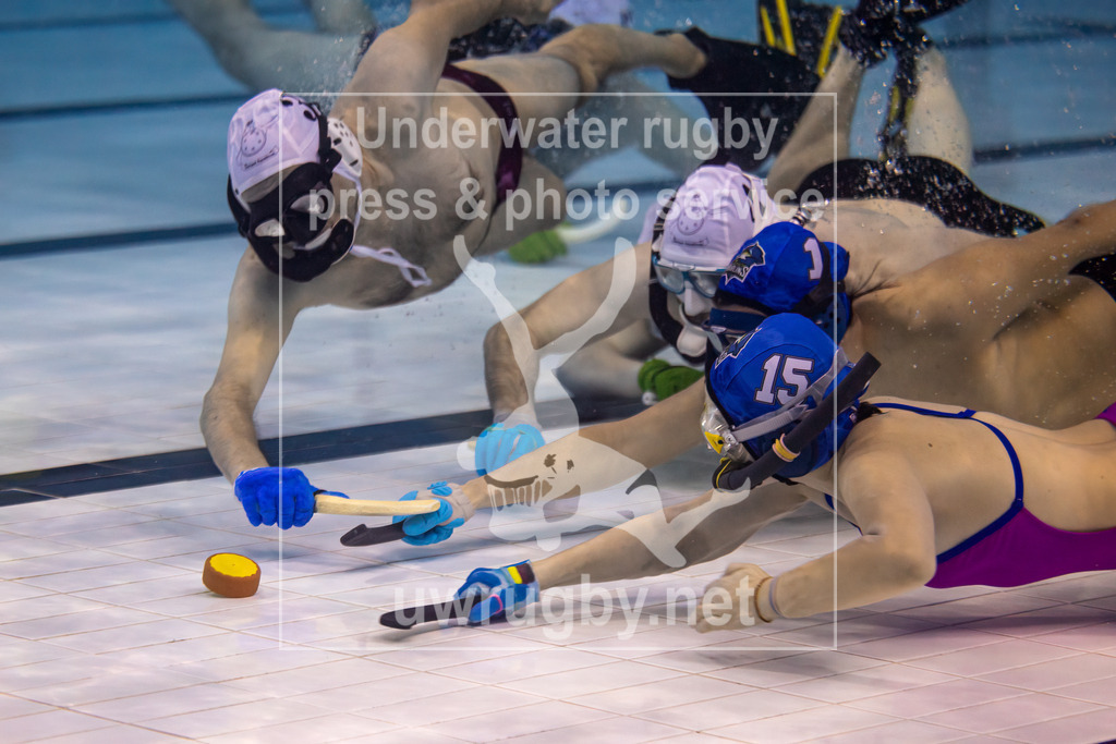 Unterwasser-Hockey: Rückrunde Liga 2023/2024 - Bild 10 | UWH München 2 in blau gegen  die Spielvereinigung Hannover / Elmshorn in weiß. Kampf um den Puck auf dem Boden des Schwimmbeckens. - Realisiert mit Pictrs.com