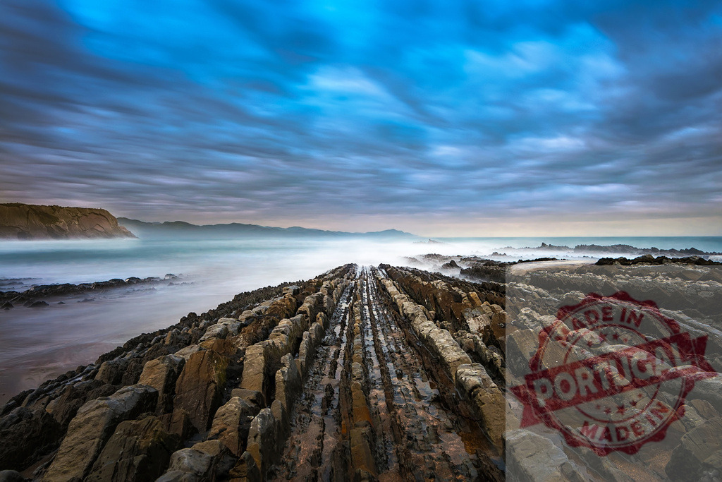 Sakoneta beach flysch at sunset with dramatic sky and moving sea in Basque Country | Long exposure photography of flysch rock formations leading to the sea under a dramatic sky at Sakoneta beach, Basque Country - Realisiert mit Pictrs.com