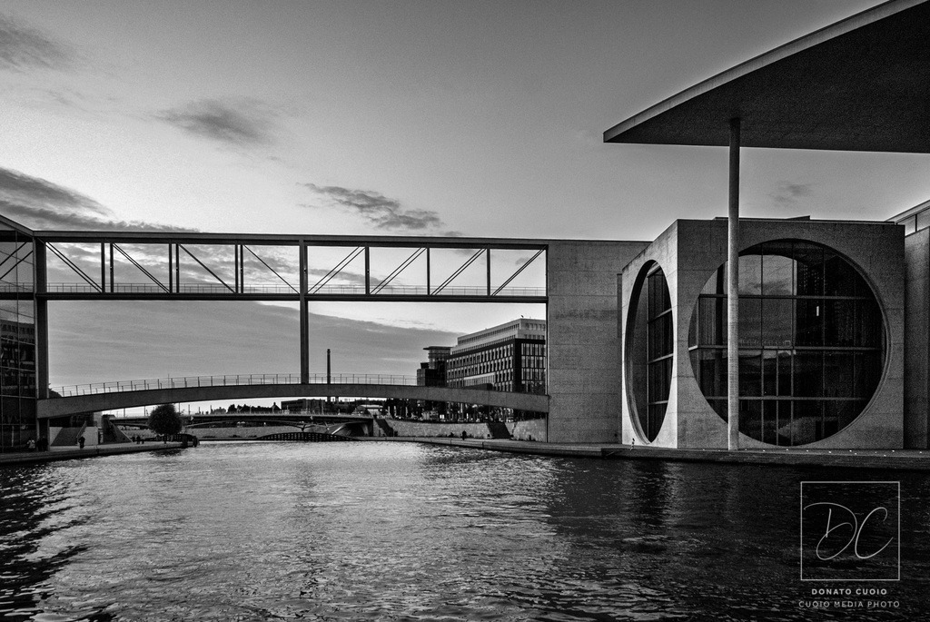 Berlin – Stillstand der Zeit | Dieses Fine-Art-Foto zeigt die moderne Architektur Berlins in einer reduzierten, zeitlosen Schwarzweiß-Ästhetik.Durch die Langzeitbelichtung verschwimmen Bewegung und Raum, während die massiven Strukturen ruhig und unverrückbar stehen bleiben.Der Kontrast zwischen weichem Wasser, dramatischem Himmel und klaren Linien der Architektur verleiht dem Motiv eine besondere Tiefe und Präsenz.Ein Bild, das nicht laut wirkt – sondern bleibt.Ideal für moderne Wohnräume, Büros, Kanzleien und alle, die Architektur als Kunst verstehen.Materialempfehlung:- Acrylglas + Alu-Dibond glanz → maximale Wirkung- Alu-Dibond matt → elegant & modern- Fineart Hahnemühle → dezenter Stil - Realisiert mit Pictrs.com