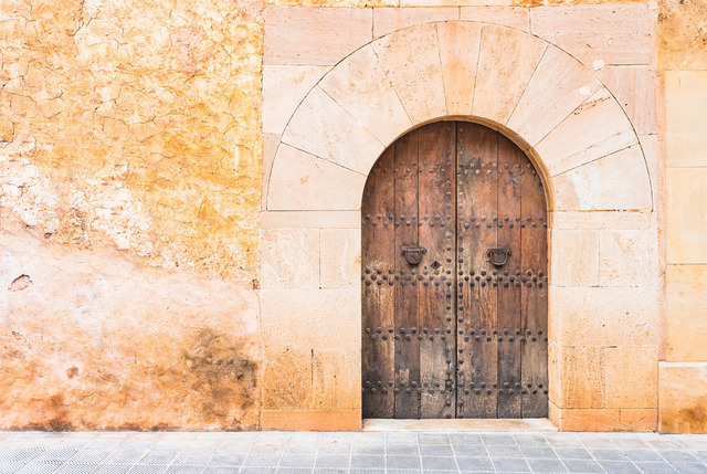 Old mansion wooden front door and rustic wall background | Close-up of vintage mansion with old wooden door and rustic wall - Realisiert mit Pictrs.com